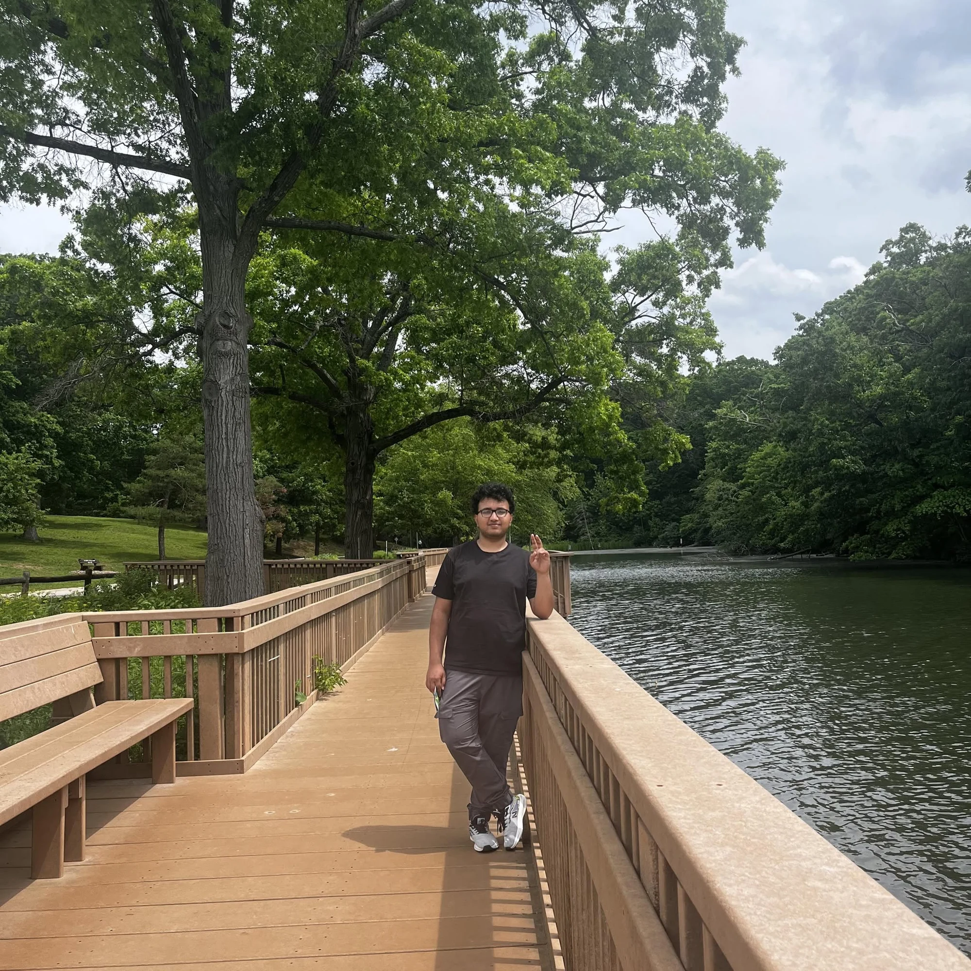 Bibas Pokhrel standing on a pedestrian bridge over a stream